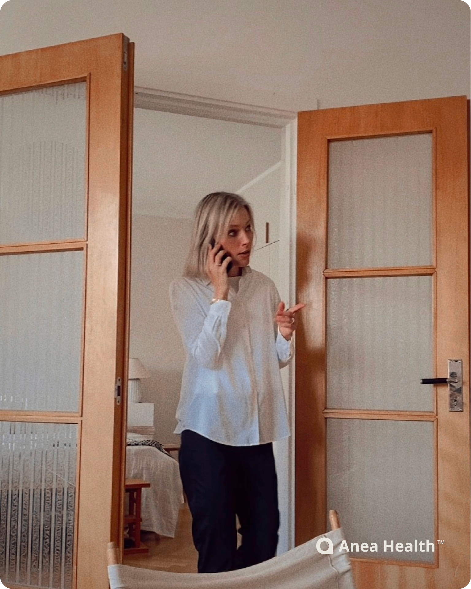 Woman standing in a doorway while speaking on the phone